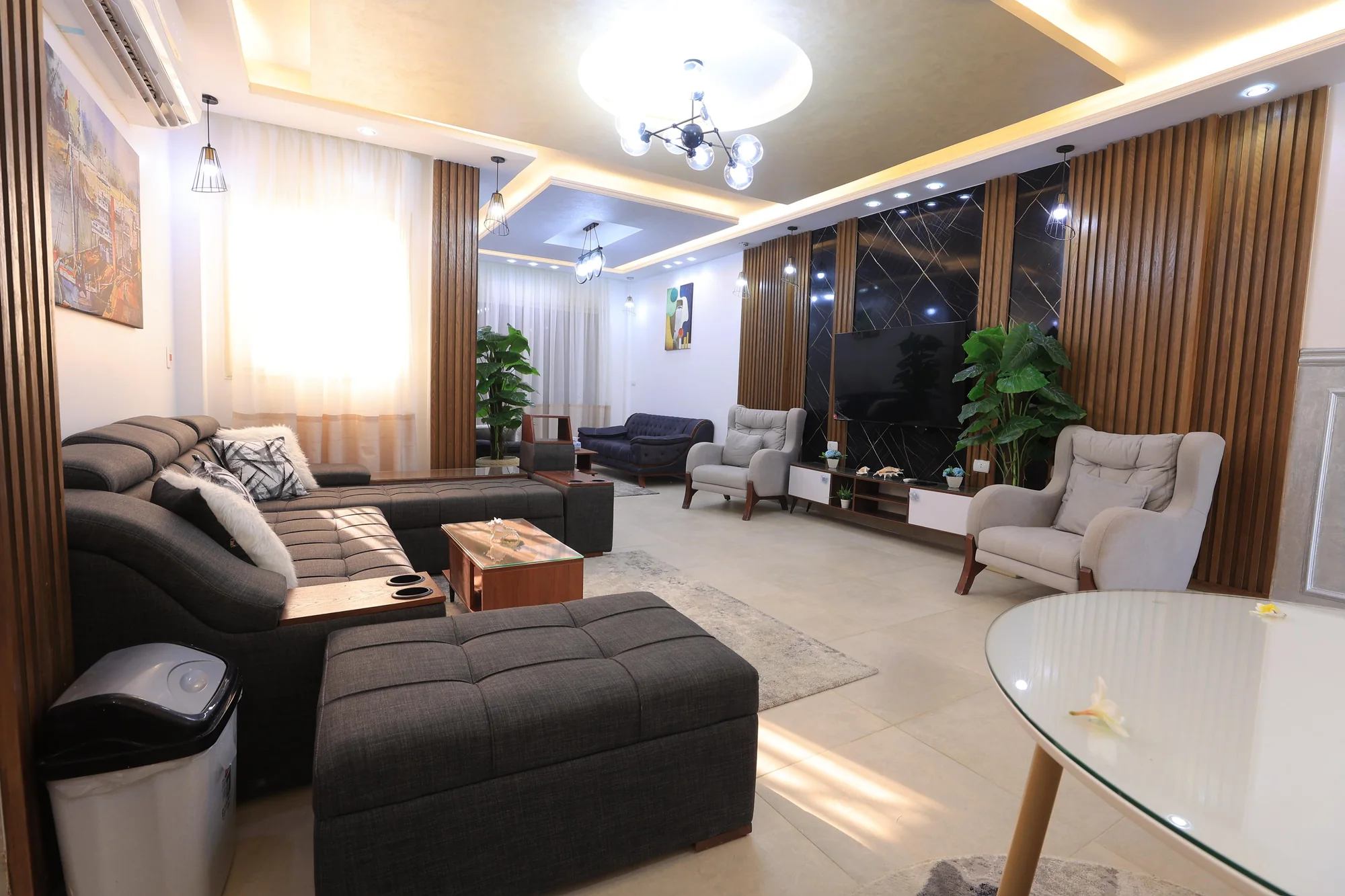 Warm timber joinery, a composed TV wall and layered lighting connect the living spaces of Villa 205.