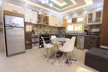Kitchens: timber and light kitchen cabinets with a dining table (view 4)