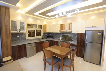 Kitchens: timber and light kitchen cabinets with a dining table (view 5)